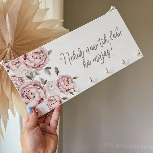 "NEKUR NAV TIK LABI KĀ MĀJĀS" DEKORS ATSLĒGĀM AR ROZĀ ZIEDIEM