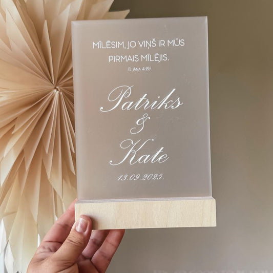 "MĪLĒSIM, JO VIŅŠ MŪS PIRMAIS IR MĪLĒJIS" STIKLA DEKORS KOKA STATĪVĀ AR BALTIEM ZIEDIEM (Copy)